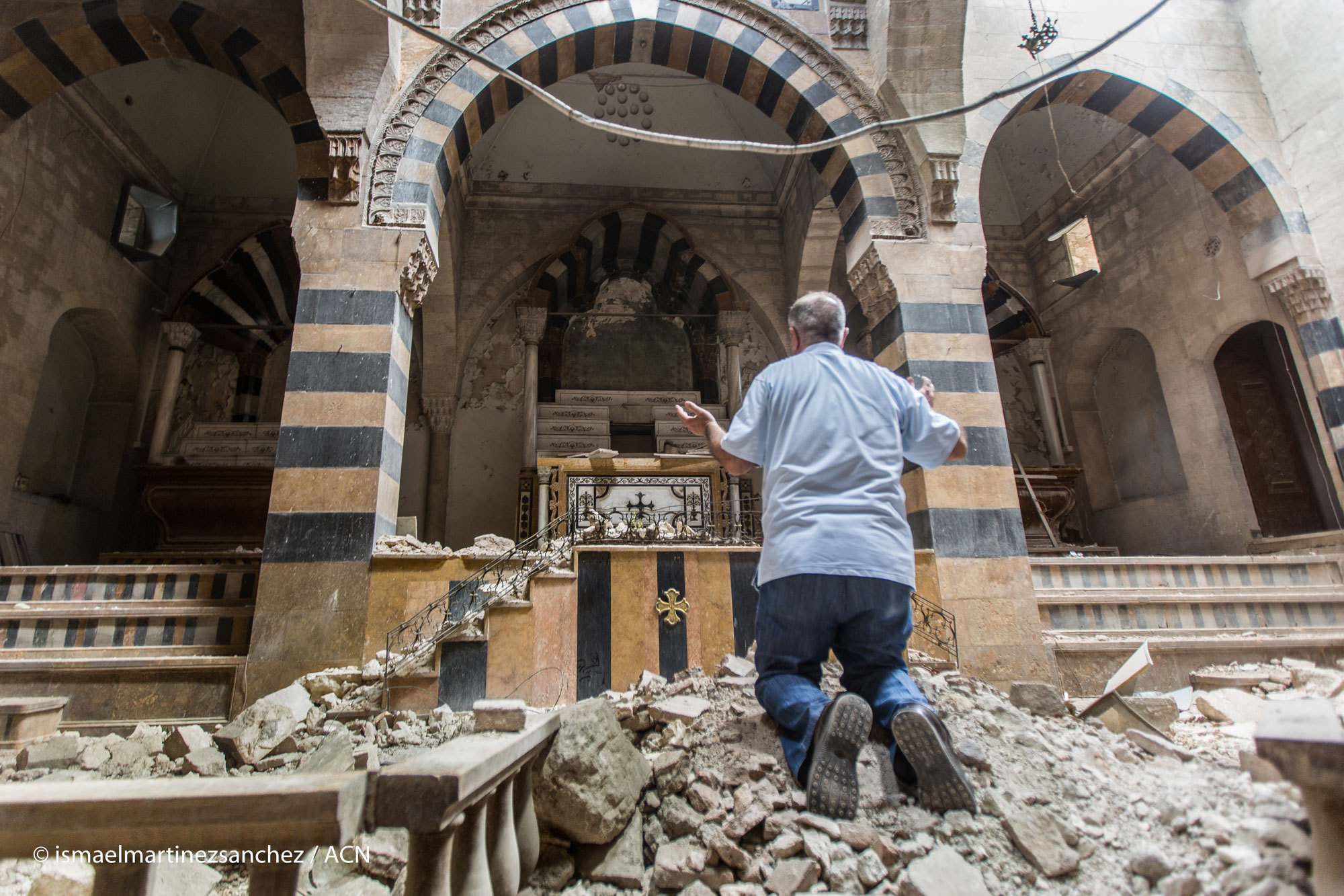 Ein Mann betet in einer zerstörten Kirche in Syrien C KIRCHE IN NOT Ismael Martinez Sanchez
