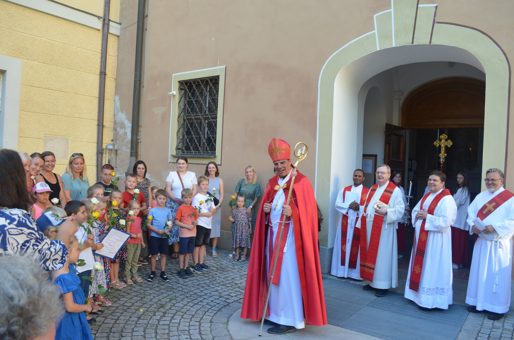 Ki Ga empfaengt Bischof vor Kircheneingang